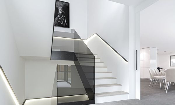 Das Rendering zeigt ein modernes Treppenhaus mit beleuchtetem Handlauf.